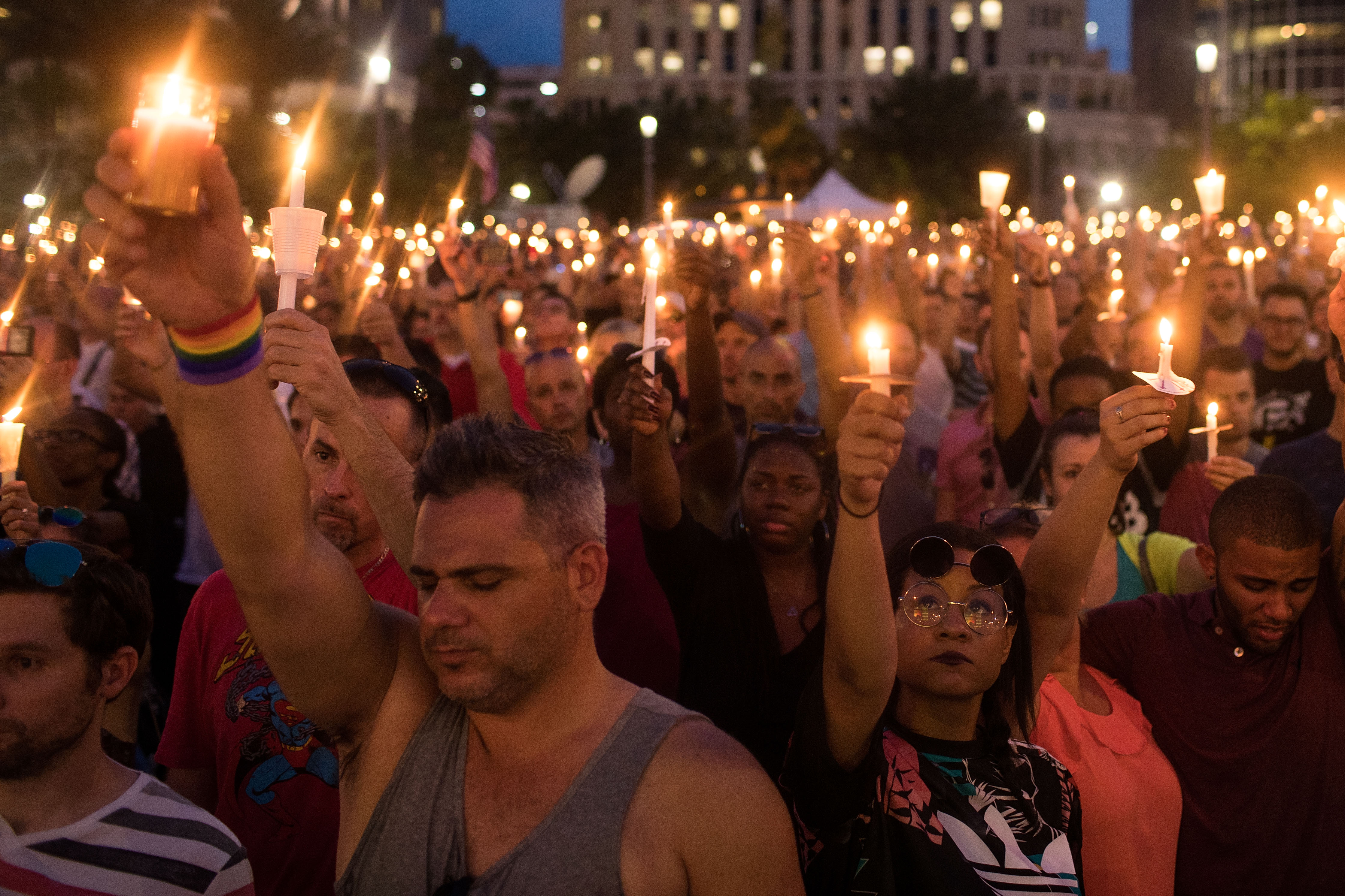 People hold candles during an evening memorial service for the victims of the Pulse Nightclub shootings, at the Dr. Phillips Center for the Performing Arts, June 13, 2016, in Orlando, Florida. The shooting at Pulse Nightclub, which killed 49 people and injured 53, is the worst mass-shooting event in American history. (Source: Drew Angerer/Getty Images)
