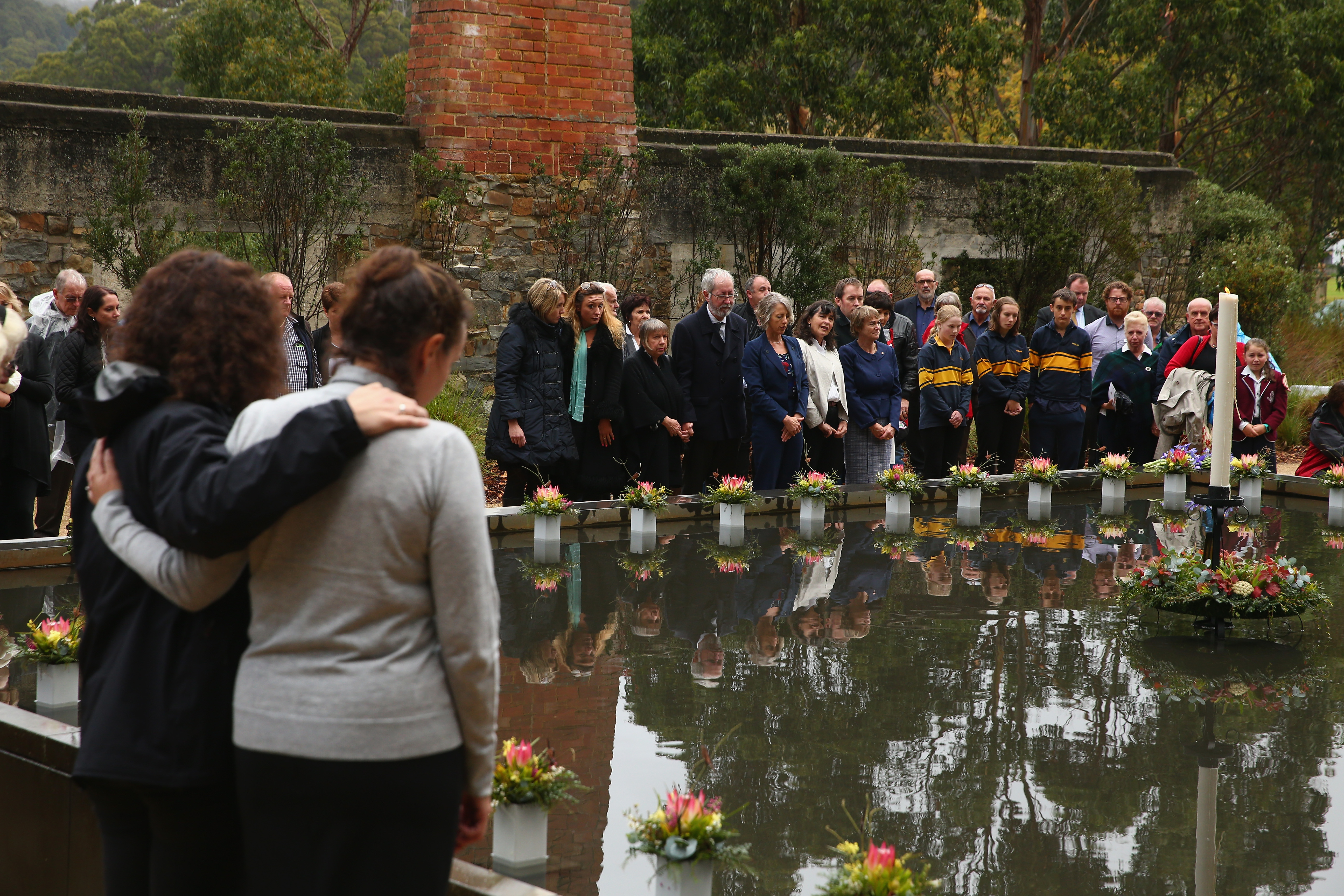Family and community members lay 35 floral tributes in the Memorial Pool to remember the victims during the 20th anniversary commemoration service of the Port Arthur massacre on April 28, 2016, in Port Arthur, Australia. The historic town became infamous on April 28, 1996, when Martin Bryant began shooting indiscriminately with a high-powered rifle on people visiting the site. 35 people were killed and a further 23 were injured in what remains the world's worst massacre by a lone gunman. The tragedy transformed gun legislation in Australia, with then- Prime Minister John Howard introducing the National Firearms Agreement, banning all semi-automatic rifles and all semi-automatic and pump-action shotguns and introducing stricter licensing and ownership controls. (Source: Robert Cianflone/Getty Images)