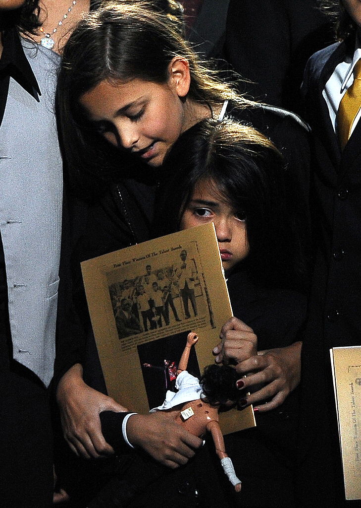 Michael Jackson's daughter Paris Jackson (top) holds her brother Prince Michael Jackson II (also known as Blanket) at the Michael Jackson public memorial service held at Staples Center on July 7, 2009 in Los Angeles, California. (Photo by Gabriel Bouys-Pool/Getty Images)