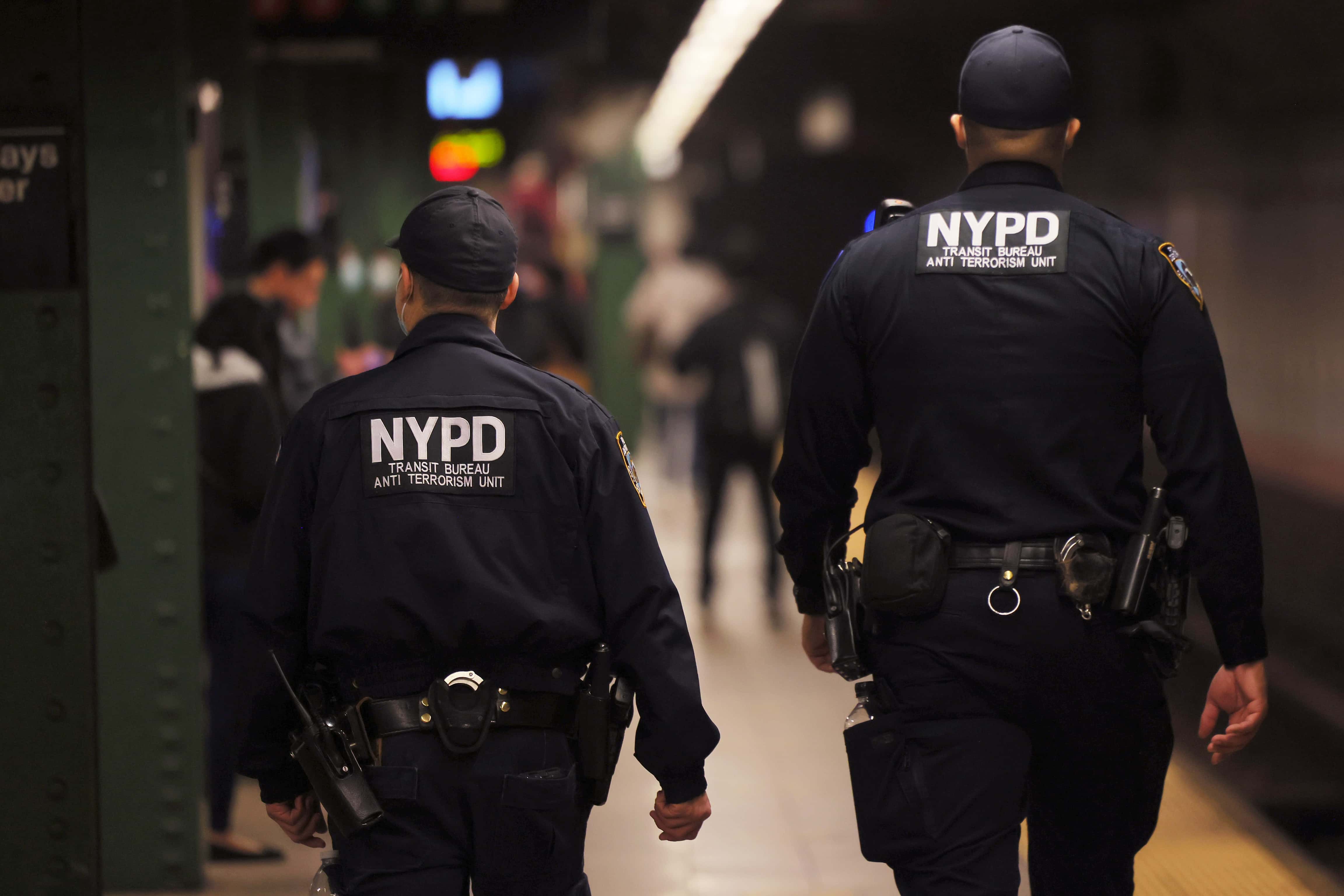 NYPD officers patrol the subway platform at the Atlantic Avenue subway station on April 13, 2022 in the Sunset Park neighborhood of Brooklyn in New York City. A manhunt is underway for a gunman who shot 10 people, critically injuring five on the N train during Tuesday's morning rush hour. The suspect, wearing a gas mask, tossed smoke grenades on the floor and fired 33 shots before leaving the scene. At least 13 other commuters suffered injuries due to smoke inhalation, falls, and panic attacks. The police on Tuesday evening named a