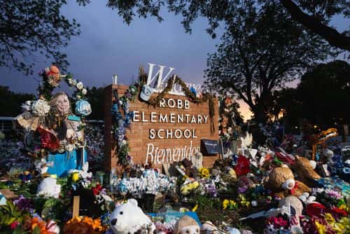 The sun sets behind the memorial for the victims of the massacre at Robb Elementary School on August 24, 2022 in Uvalde, Texas. The Consolidated Independent School District Board today fired Police Chief Pete Arredondo over police response during the May 24 massacre, America’s deadliest school shooting since 2012.