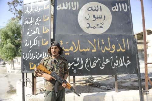A member of the Turkish-backed Free Syrian Army (FSA) stand guarded in front of a ISIS flag in the border town of Jarablus, August 31, 2016, Syria. Turkish troops and Turkey-backed rebels have been fighting Kurdish-led forces and IS since Turkey's incursion into Syria on Aug. 24. with the swift capture of Jarablus, a town a few km inside Syria that was held by Islamic State.