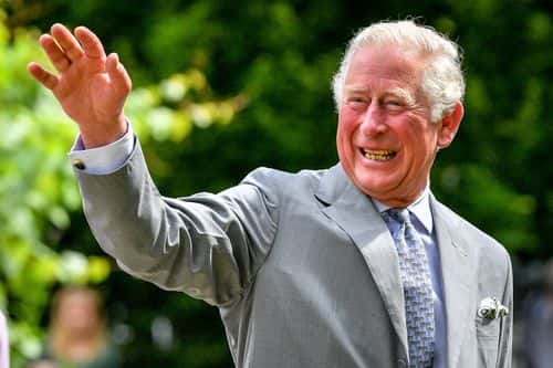 Prince Charles, Prince of Wales gestures to crowds of hospital staff watching from a distance as he chats with front line key workers who who have responded to the COVID-19 pandemic during a visit to Gloucestershire Royal Hospital on June 16, 2020 in Gloucester, England.