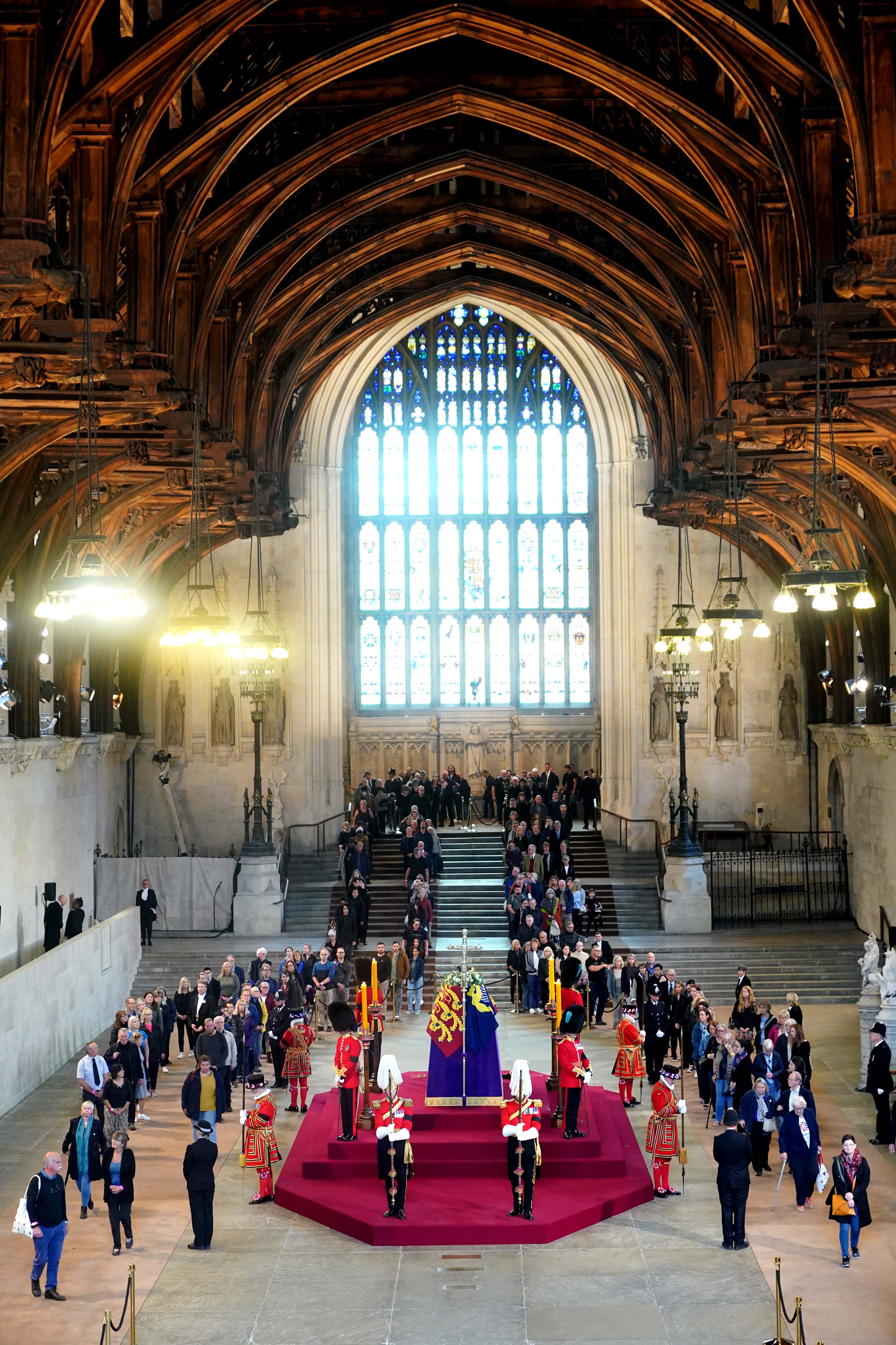 Members of the public file past the coffin of Queen Elizabeth II, draped in the Royal Standard with the Imperial State Crown and the Sovereign's orb and sceptre, lying in state on the catafalque in Westminster Hall, at the Palace of Westminster, ahead of her funeral on Monday, on September 15, 2022 in London, England. Members of the public are able to pay respects to Her Majesty Queen Elizabeth II for 23 hours a day until 06:30 on September 19, 2022.  Queen Elizabeth II died at Balmoral Castle in Scotland on September 8, 2022, and is succeeded by her eldest son, King Charles III.