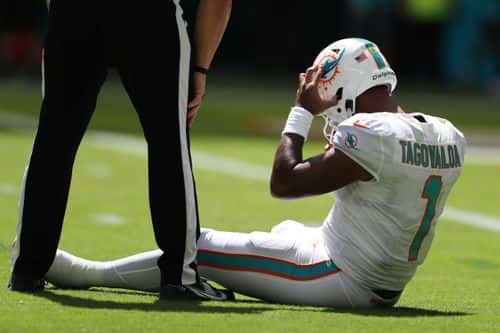 Quarterback Tua Tagovailoa #1 of the Miami Dolphins sits on the turf during the first half of the game against the Buffalo Bills at Hard Rock Stadium on September 25, 2022 in Miami Gardens, Florida.
