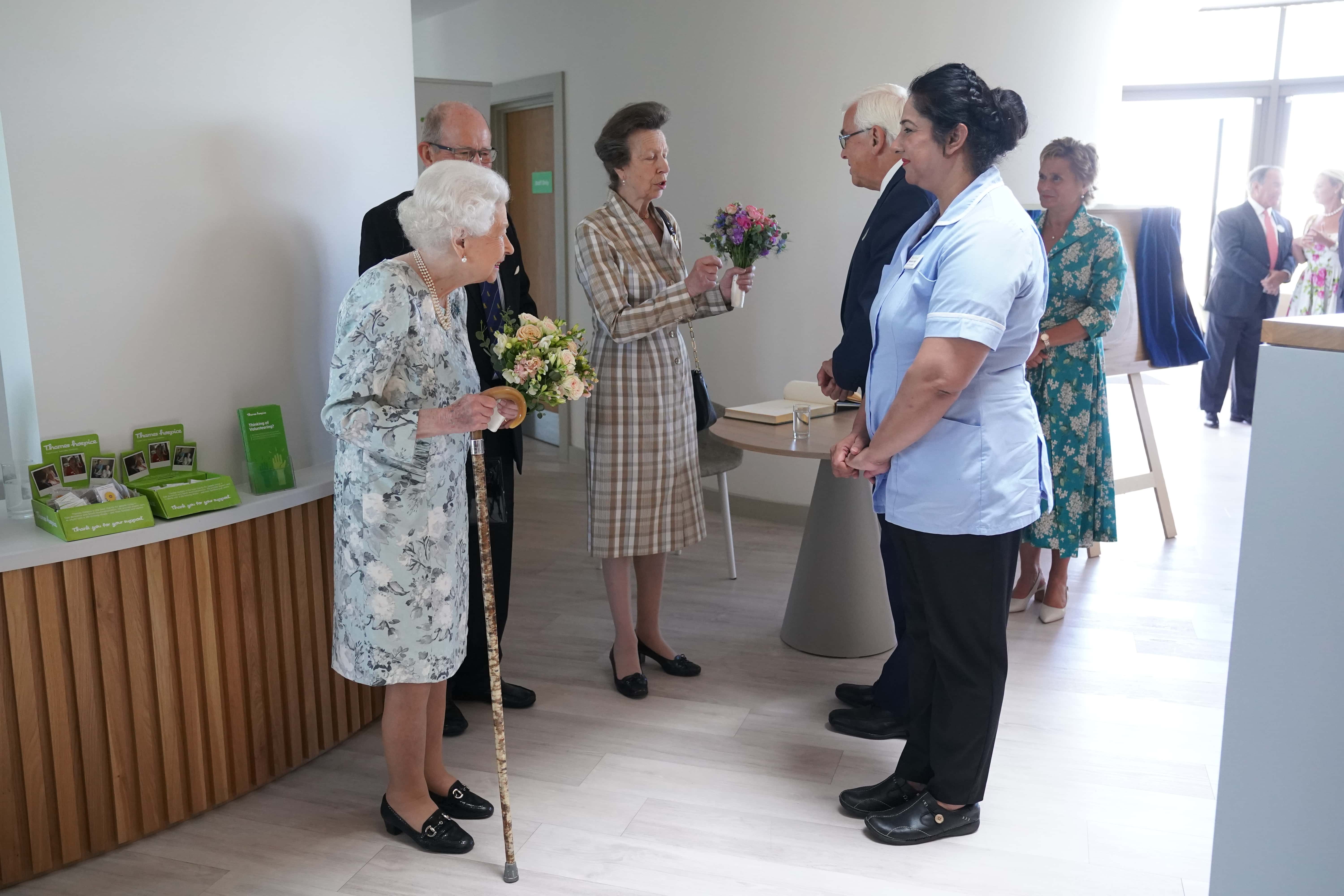 Queen Elizabeth II meets staff as Princess Anne, Princess Royal stands nearby during a visit to officially open the new building at Thames Hospice on July 15, 2022 in Maidenhead, England.
