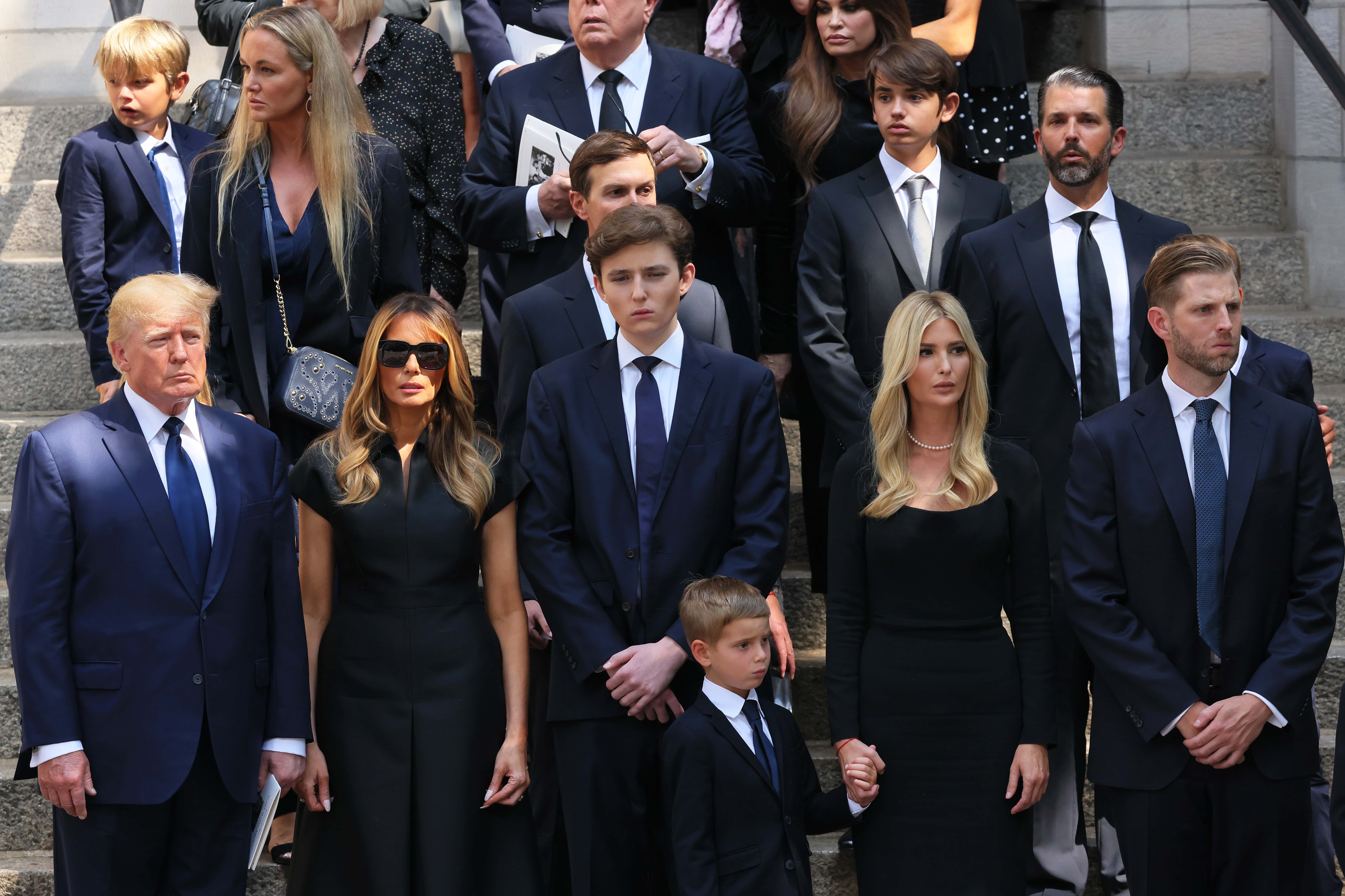 former U.S. President Donald Trump and his wife Melania Trump along with their son Barron Trump and Ivanka Trump, Eric Trump and Donald Trump Jr. and their children watch as the casket of Ivana Trump is put in a hearse outside of St. Vincent Ferrer Roman Catholic Church during her funeral on July 20, 2022 in New York City. Trump, the first wife of former U.S. President Donald Trump,  died at the age of 73 after a fall down the stairs of her Manhattan home.