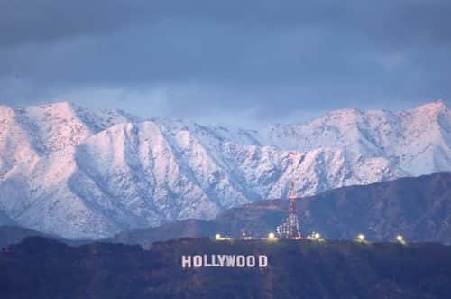 The Hollywood sign stands in front of snow-covered mountains after another winter storm hit Southern California on March 01, 2023 in Los Angeles, California. The final in a series of winter storms in the Los Angeles region brought snow levels to as low as 1,000 feet in some places while further boosting the snowpack. California’s snowpack level stands at 189 percent of the average for March 1, according to the California Department of Water Resources. California Governor Gavin Newsom has declared a state of emergency due to winter storms for 13 counties including Los Angeles County.