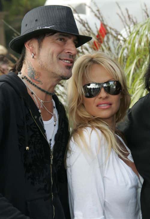 (US TABS AND HOLLYWOOD REPORTER OUT) Musician Tommy Lee and actress Pamela Anderson pose at the home of John Paul DeJoria, CEO and co-founder of John Paul Mitchell Haircare Systems, during his annual party to thank movie, television and music star friends and his co-workers for their charitable work on December 24, 2005 in Malibu, California.