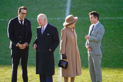 King Charles III and Camilla, Queen Consort talk to Co-Owners Wrexham AFC Ryan Reynolds (L) and Rob McElhenney (R) during their visit to Wrexham AFC on December 09, 2022 in Wrexham, Wales. Formed in 1864, Wrexham AFC is the third oldest professional football team in the world. The club was taken over by Hollywood actors Ryan Reynolds and Rob McElhenney in late 2020.