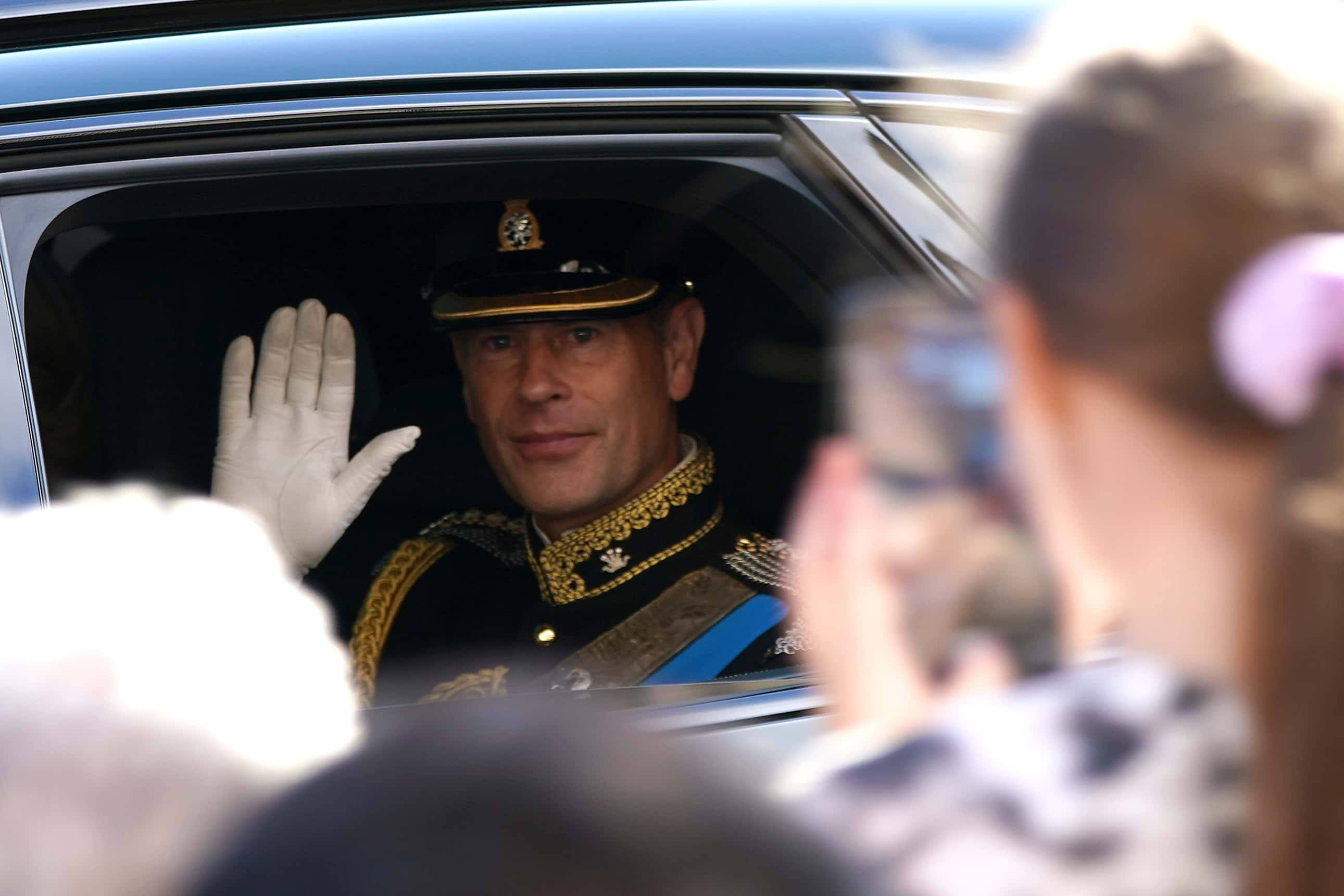Prince Edward, Duke of Wessex waves to the crowd as he returns down the Royal Mile to the Palace of Holyrodhouse after following the coffin of Queen Elizabeth II in procession from the Palace of Holyroodhouse to St Giles' Cathedral, where it will lie at rest for twenty-four hours, on September 12, 2022 in Edinburgh, Scotland. King Charles III joins the procession accompanying Her Majesty The Queen's coffin from the Palace of Holyroodhouse along the Royal Mile to St Giles Cathedral. The King and The Queen Consort, accompanied by other Members of the Royal Family also attend a Service of Prayer and Reflection for the Life of The Queen where it lies in rest for 24 hours before being transferred by air to London.