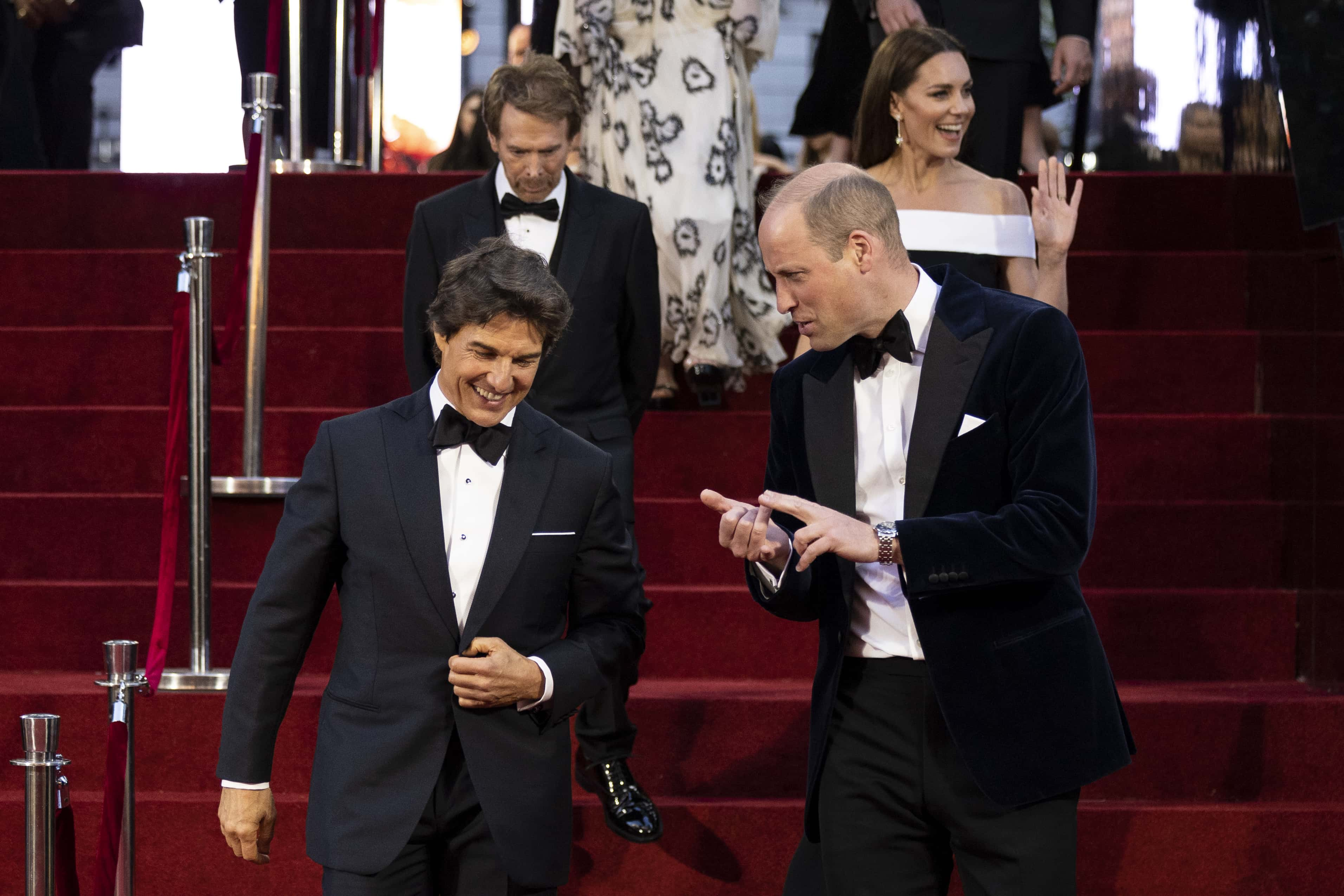 Prince William, Duke of Cambridge talks with actor Tom Cruise (L) as they attend the