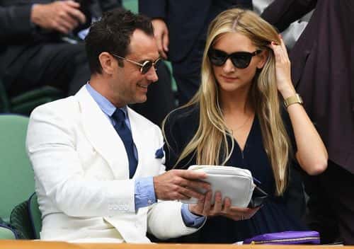 Jude Law and Phillipa Coan watch on as Roger Federer of Switzerland plays Milos Raonic of Canada in the Men's Singles Semi Final match on day eleven of the Wimbledon Lawn Tennis Championships at the All England Lawn Tennis and Croquet Club on July 8, 2016 in London, England.