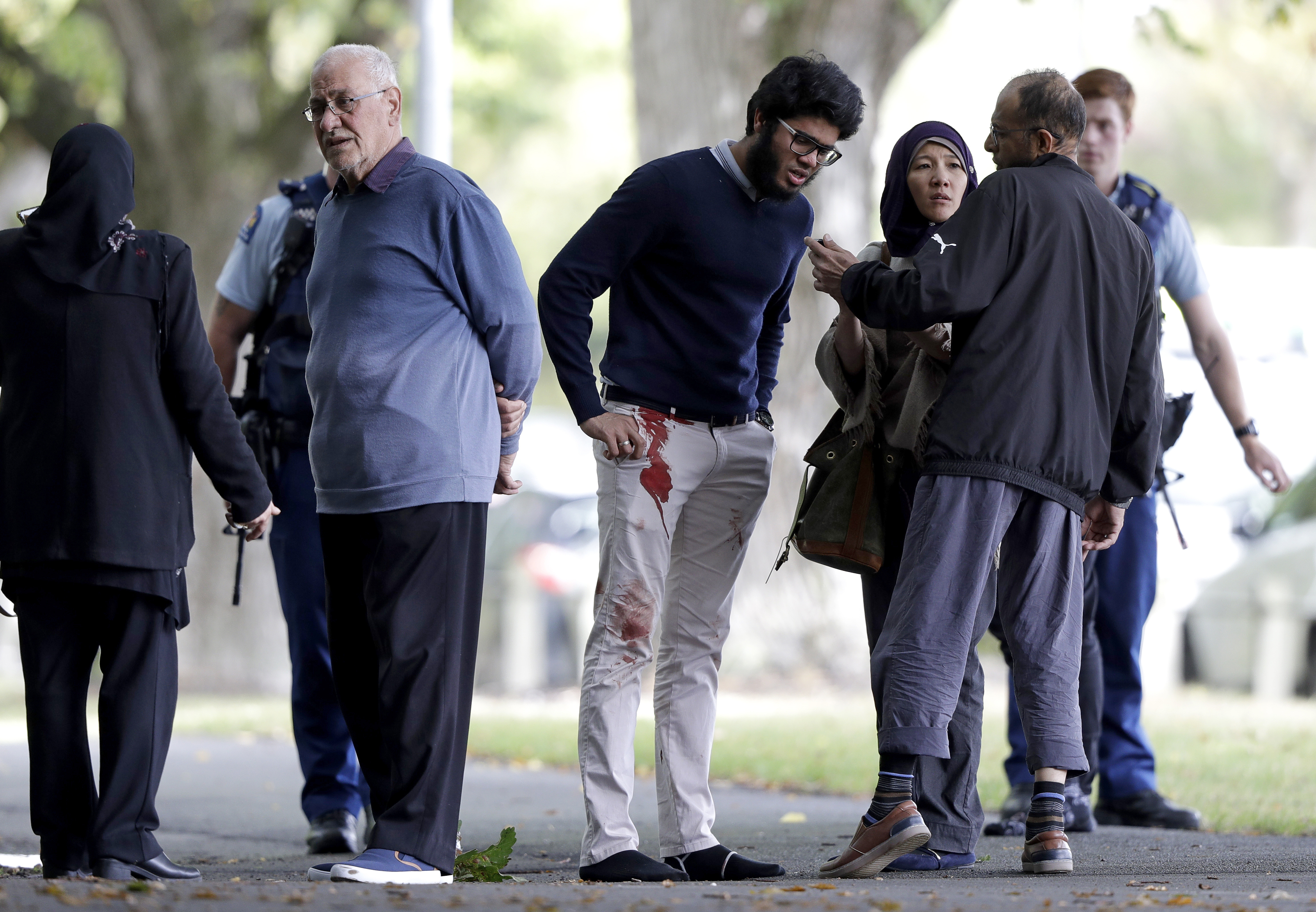 People stand across the road from a mosque in central Christchurch, New Zealand, Friday, March 15, 2019. A witness says a number of people have been killed in a mass shooting at a mosque in the New Zealand city of Christchurch; police urge people to stay indoors.(AP Photo/Mark Baker)