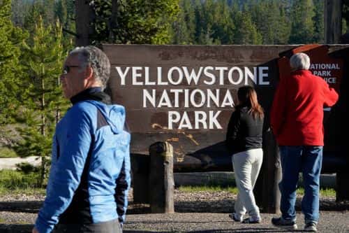 People wait at sunrise outside the south entrance of Yellowstone National Park to gain entry to the park for the first time in more than a week on June 22, 2022 in Yellowstone National Park, Wyoming. The park has been closed to all visitors due to severe flooding and damage to the roads. There is a limited opening today for the southern loop of the park.