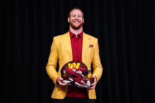 Quarterback Carson Wentz of the Washington Commanders stands with a helmet after being introduced at Inova Sports Performance Center on March 17, 2022 in Ashburn, Virginia.