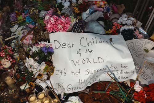 A sign is left on top of flowers at a memorial for the victims of the mass shooting at Robb Elementary School on June 25, 2022 in Uvalde, Texas. The Uvalde community is marking one month since the deadly shooting where 19 students and 2 teachers were killed.