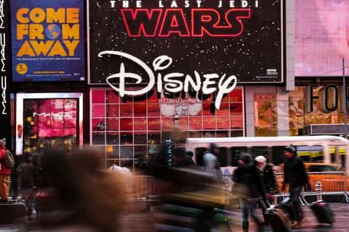 The Disney logo is displayed outside the Disney Store in Times Square, December 14, 2017 in New York City. The Walt Disney Company announced on Thursday morning that it had reached a deal to purchase most of the assets of 21st Century Fox. The deal has a total value of around $66 billion, with Disney assuming $13.7 billion of Fox's net debt.