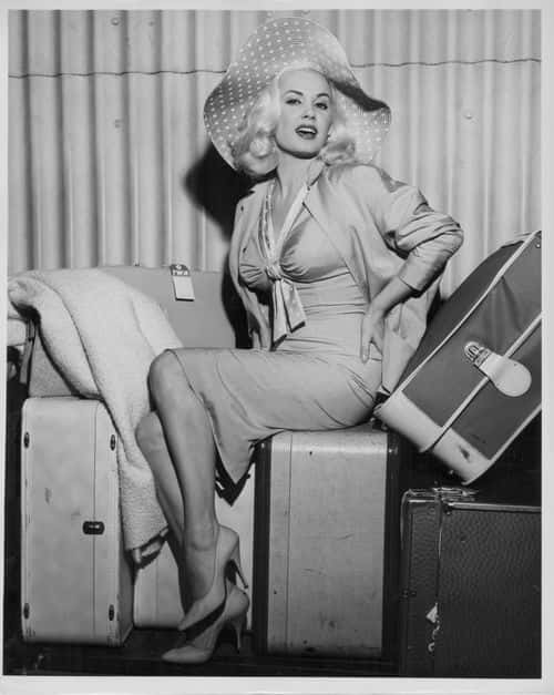 Actress Mamie Van Doren sitting in a glamorous pose on top of her luggage, as she arrives in New York with Trans World Airlines, Idlewild Airport, circa 1958. (Photo by Keystone/Hulton Archive/Getty Images)