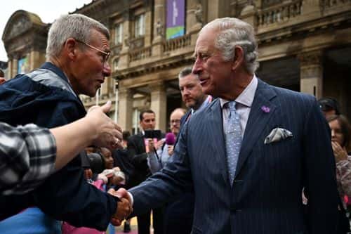 Britain's Prince Charles, Prince of Wales shakes hands with a visitor during a visit to the Commonwealth Games 'Festival Site' at Victoria Square on the eve of the Commonwealth Games, on July 28, 2022, in Birmingham, England.