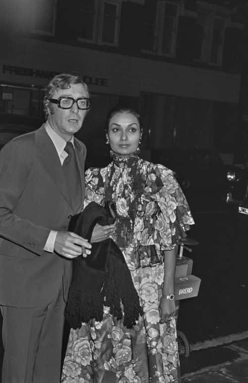 English actor Michael Caine with his wife Shakira at the charity premiere of 'The Optimists of Nine Elms' at the ABC Cinema in London, UK, 25th April 1974.  (Photo by Larry Ellis/Express/Hulton Archive/Getty Images)