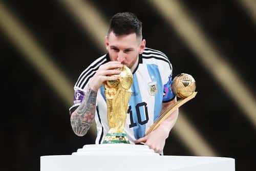 Lionel Messi of Argentina kisses the FIFA World Cup Qatar 2022 Winners' Trophy while holding the adidas Golden Boot award after the FIFA World Cup Qatar 2022 Final match between Argentina and France at Lusail Stadium on December 18, 2022 in Lusail City, Qatar.